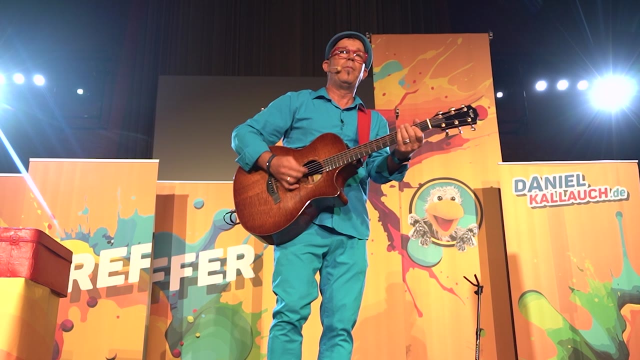 Daniel Kallauch spielt Gitarre auf der Bühne